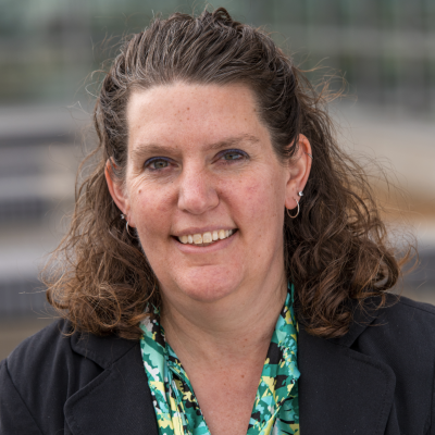 Curly haired brunette woman wearing a maroon collared shirt