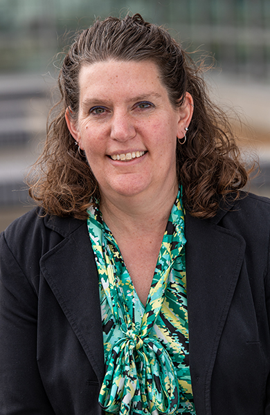 female executive wearing a black jacket and green shirt