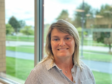 female executive wearing a grey and white striped shirt