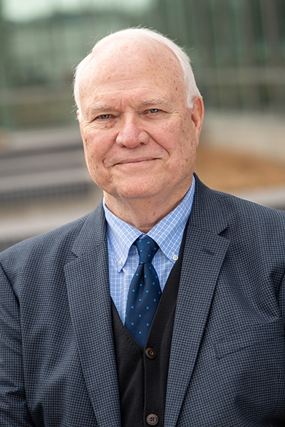 male executive wearing a grey jacket, blue shirt and blue tie