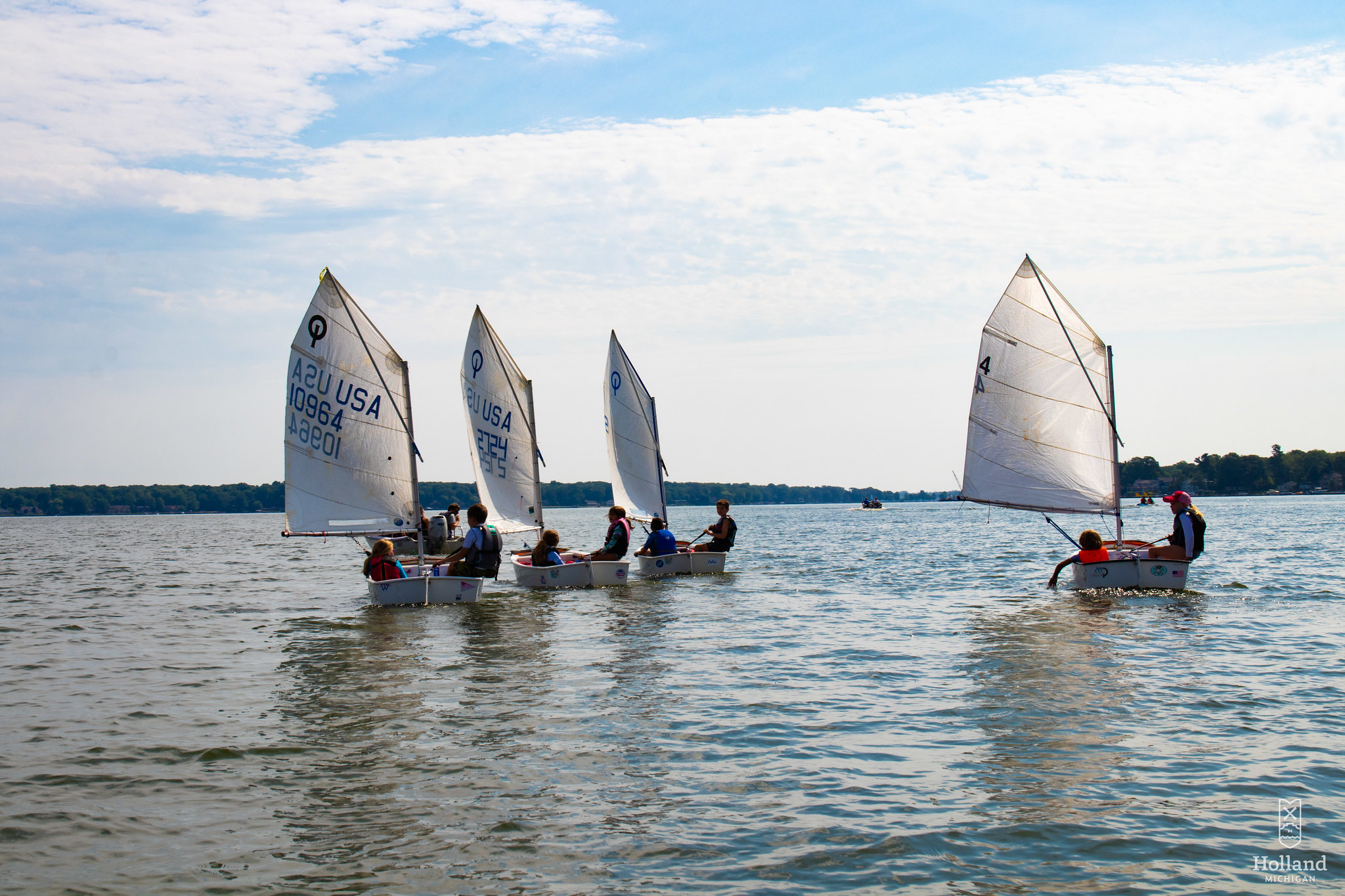 Four sailboats on a calm Lake Macatawa