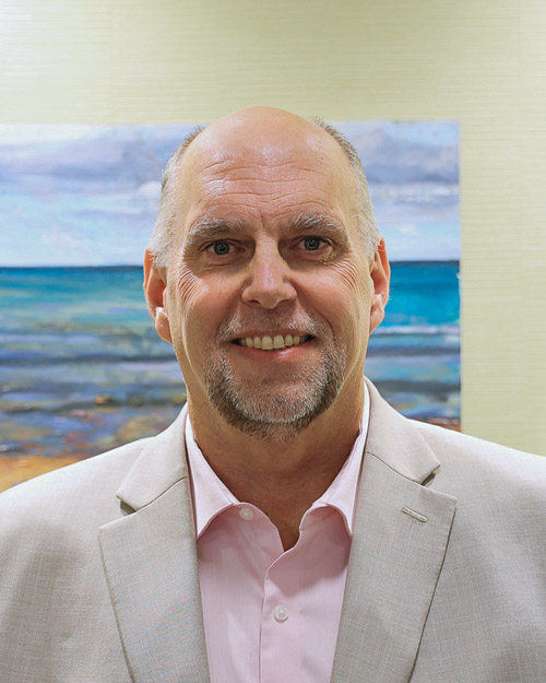 male executive wearing a pink button down with a khaki blazer