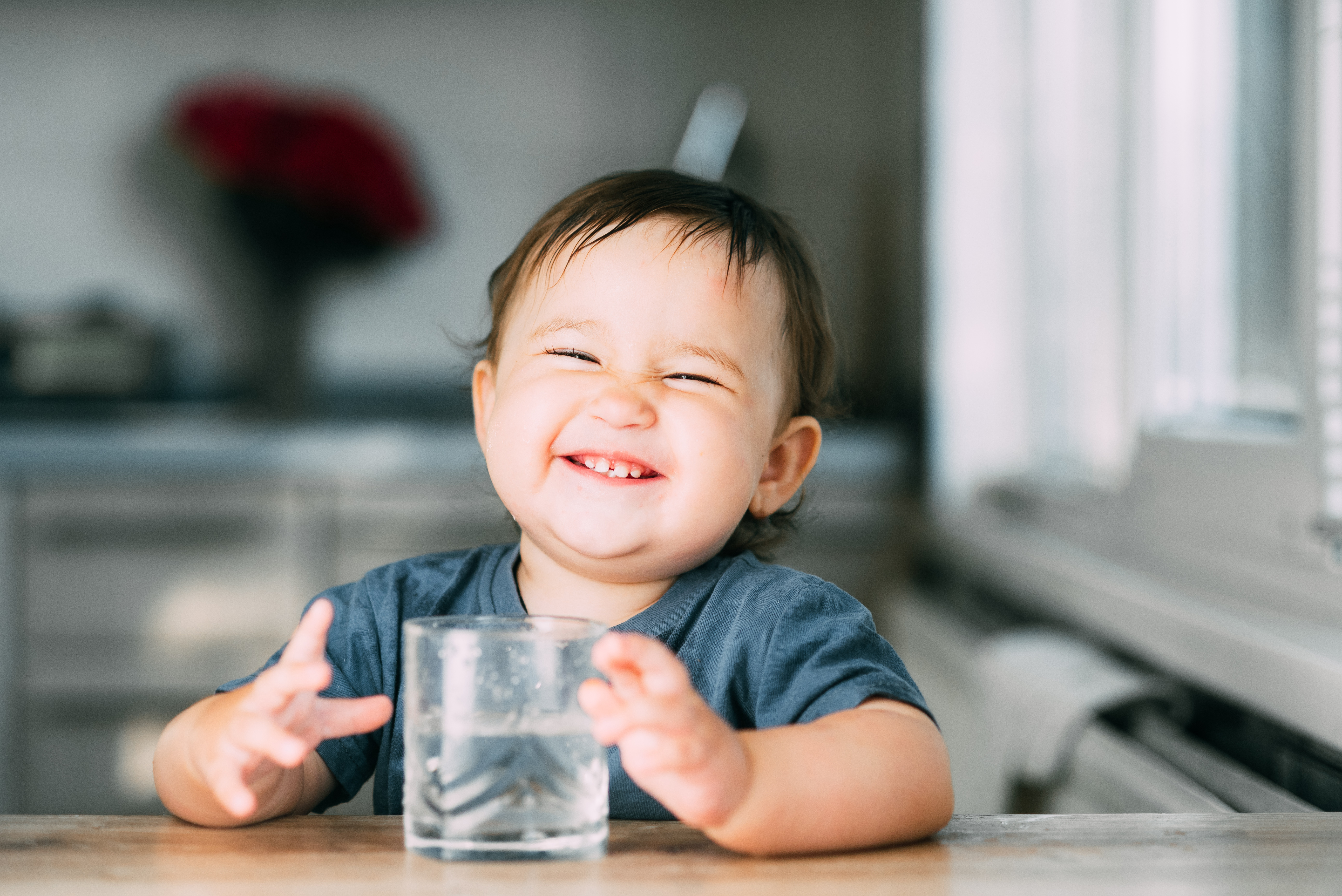 Toddler smiling with glass of water