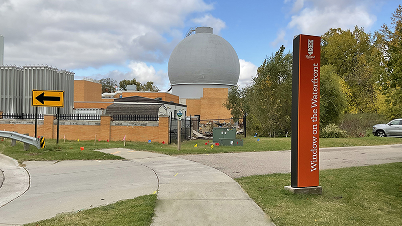 sidewalk leading to a gray anaerobic digester round tank