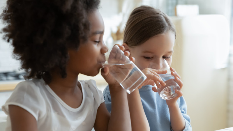 Two girls drinking glasses of water